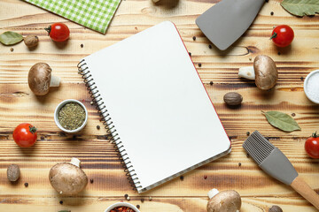 Composition with blank recipe book, kitchen utensils, vegetables and spices on wooden background