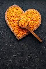 Red lentils in bowl and spoon - Lens culinaris organic.