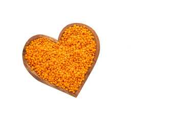 Lens culinaris - Organic unshelled red lentil in heart bowl.