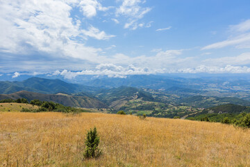 Expansive View of Mountainous Landscape with Rolling Hills and Bright Sky