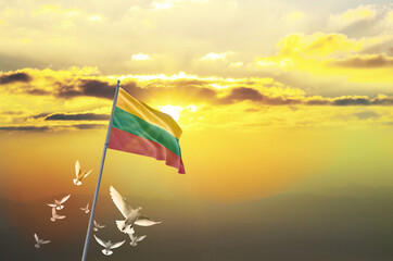 Lithuania flag waving with flying doves against sunset or sunrise. Lithuania flag for Republic Day...