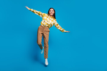 Photo of charming glamour cheerful woman wear trendy clothes fly air jump up isolated on blue color...