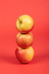 Three Fresh Red and Yellow Apples on Vibrant Red Background – Isolated, Healthy Fruit, and Nutrition Concept