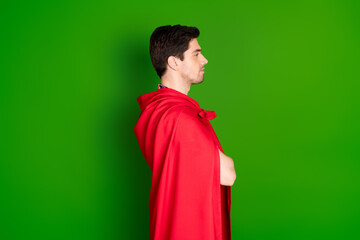 Side profile photo of serious guy dressed shirt red cloak hold arms folded look at logo empty space isolated on green color background