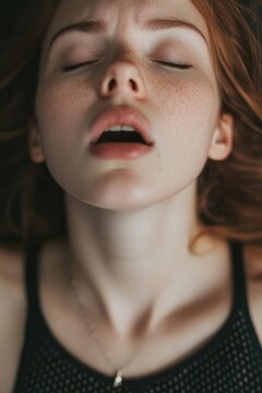moaning young sensual caucasian woman with open mouth and closed eyes getting sexual pleasure, orgasm, top view portrait. erotic, sex, masturbation and cunnilingus.