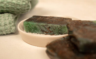 Handmade Green and Brown Soap Bars Resting on a White Dish