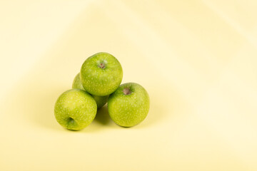 Fresh Green Apples: Trio of Crisp Granny Smith Fruits on Pale Yellow Background - Healthy Snack,...