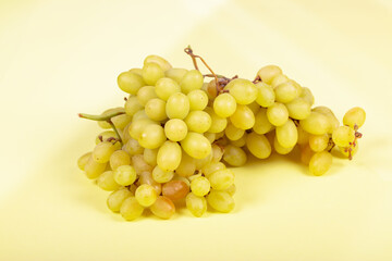 Fresh Green Grapes: Juicy Bunch of Sweet Table Grapes on Pale Yellow Background - Healthy Snack, Organic Produce, and Natural Fruit Photography