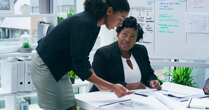 Young female manager with tablet working with colleagues in modern office. Project supervisor walking around and showing team members tasks using technology. Collaboration and teamwork