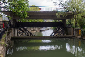 A view of the Pulteney Weir flood gates and foot bridge on the River Avon in Bath Somerset, England.