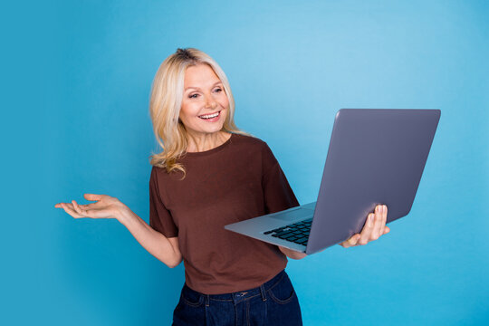 Photo of cute charming senior woman wear stylish brown clothes hold dadget isolated on blue color background