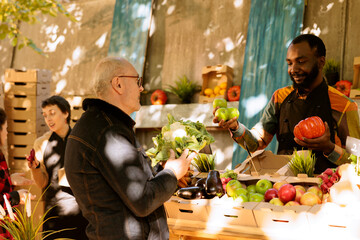 African american man displaying bio fruits or vegetables at small business farming shop, locally...