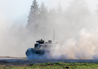 Challenger 2 tank or FV4034 driving down a dirt road on a training area 