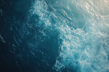 Fototapeta premium Waves Crashing in the Sunlight Over Deep Blue Ocean Waters Near the Coastline During a Calm Summer Day