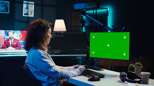 Developer doing software debugging on green screen PC at home, checking lines of code displayed on monitors. IT professional in living room fixing coding problems on mockup computer, camera B