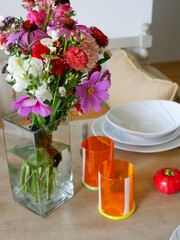 Colorful table setting, bouqet of flowers. Interior design.
