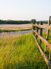 Beautiful golden summer field. Hay bales laying everywhere. Summertime landscape photography over meadow.