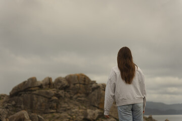 Woman facing the horizon at Castro de Baroña ruins