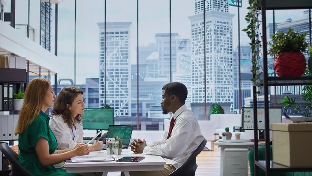 Recruitment team conducts an interview with a professional job applicant, evaluating their resume and discussing their background. HR employees addressing a series of questions. Camera B.