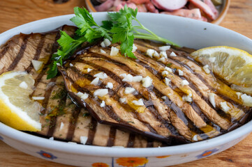 Italian style starter served in restaurant, grilled eggplant with garlic, olive oil and fresh parsley