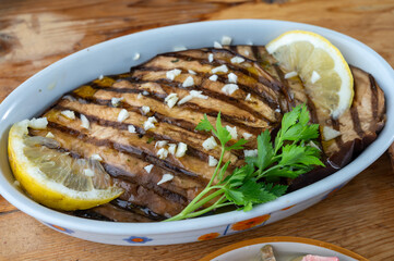 Italian style starter served in restaurant, grilled eggplant with garlic, olive oil and fresh parsley