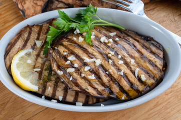 Italian style starter served in restaurant, grilled eggplant with garlic, olive oil and fresh parsley