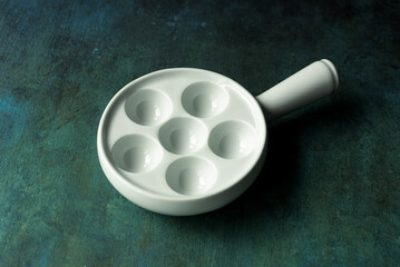 Empty escargot plate on rustic background.