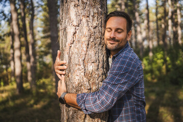 Adult man happily hug tree in forest show appreciation of nature