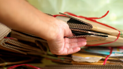 Elderly man recycles cardboard boxes, plastic bottles at home