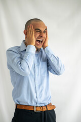 Young man screaming with his hands on his head. Angry boy with a bad headache screaming very loudly