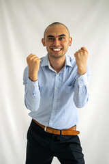 Very cheerful and euphoric young man celebrating by clenching his fists
