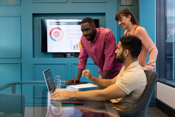 Business team discussing project, using laptop and presentation in modern office