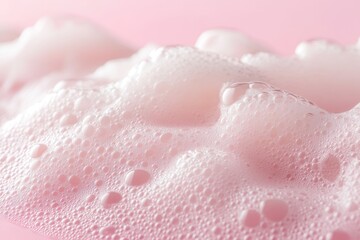 Soft pink foam with fine bubbles on a smooth surface in a macro shot, showcasing delicate textures and color nuances
