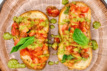 Traditional Italian appetizer,homemade bruscheta with tomatoes and basil served on brown plate, isolated on white background