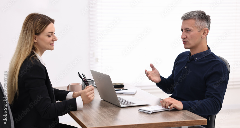 Sticker Banker working with client at table in office