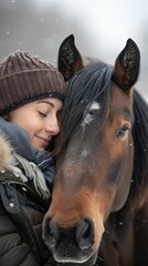Fototapeta premium Woman cuddling horse in a snowy winter scene