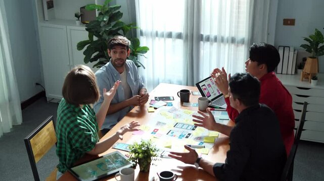 Top view of business team brainstorming idea by using mind map while putting hand together. People designing Ux Ui design for mobile phone while making stack of hands and clapping hand. Convocation.