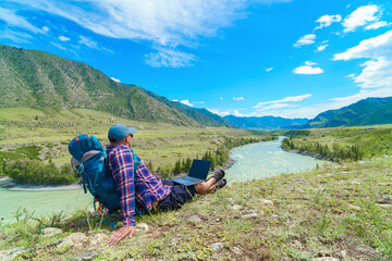hiker man with laptop in the countryside