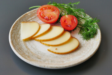 Deliciously Sliced Cheese Accompanied by Fresh Juicy Tomatoes and Aromatic Herbs on a Plate