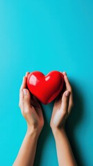 Obraz premium Hands holding a red heart shape on a blue background