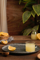 lemon juice and lemon slices with a darkmood photo concept on a brown wooden background