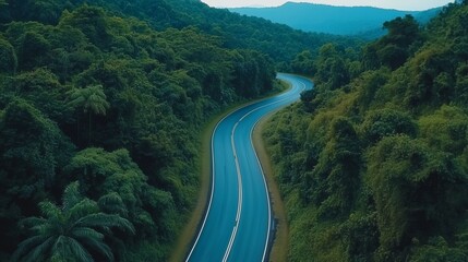 Fototapeta premium Asphalt road way in green forest mountain valley aerial view