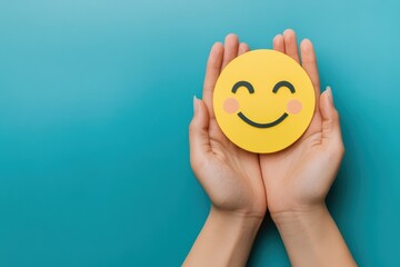 Paper cut smiley face in hands on plain blue background.
