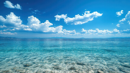 Obraz premium stunning view of crystal clear sea meeting horizon under vibrant blue sky filled with fluffy clouds. tranquil waters reflect beauty of nature, creating serene atmosphere