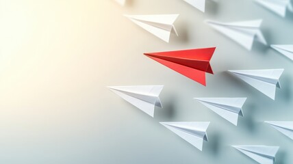 Fototapeta premium A striking image of a red paper airplane leading a group of white ones, symbolizing leadership and innovation in a creative context.