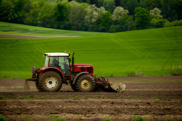 Obraz premium modern tractor with attached plow works diligently in vast green field, showcasing beauty of agricultural life and importance of farming