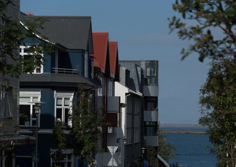 Row of condo buildings with  traditional painted roofs  leading to harbor