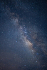 The sky is filled with stars and the Milky Way. The stars are scattered throughout the sky, creating a sense of depth and vastness. The Milky Way is a beautiful and awe-inspiring sight