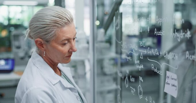 Mature, scientist and planning with glass in laboratory for chemical equation development, experiment and medical study. Woman, board and thinking or problem solving, acetic acid and aspirin reaction