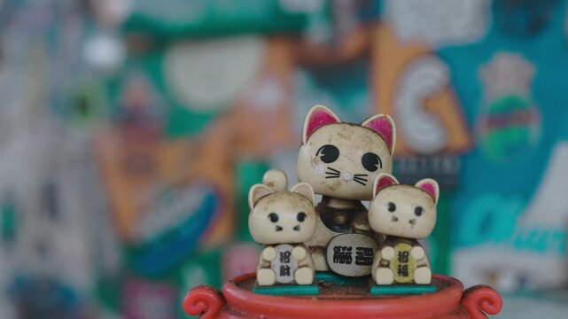 Three bobbing heads luck cats cinematic slow motion